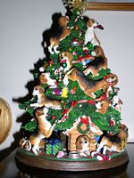 Beagles climbing all over a Christmas Tree 